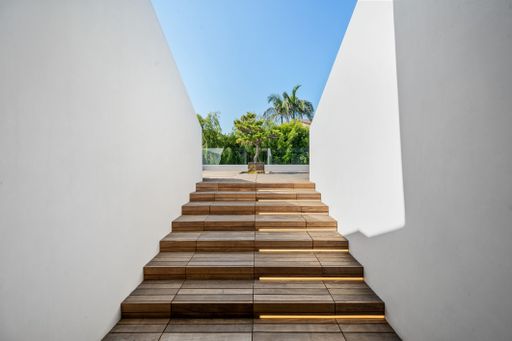 A wooden and concrete architectural structure with wooden stairs