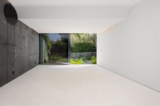 A room with concrete walls and sliding glass doors