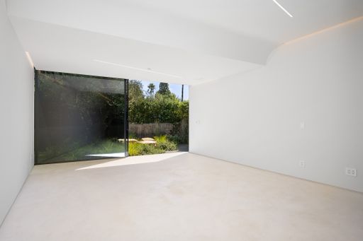 Minimalist white room with corner windows and green plant wall