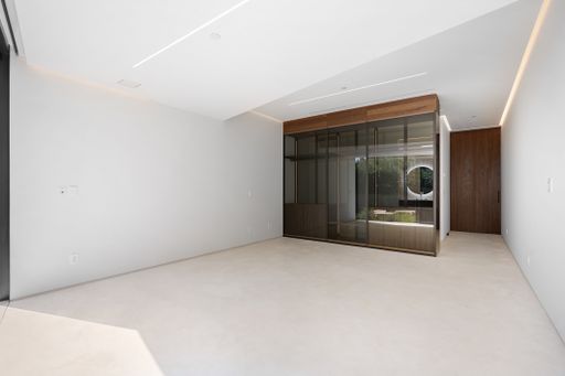 A minimalist room with white walls and sliding glass doors
