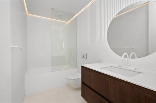 Small bathroom with oversized round mirror above sink