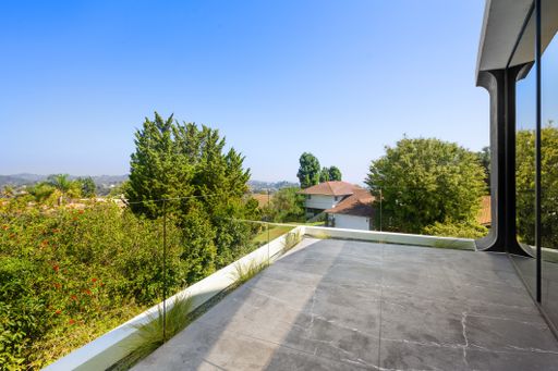 A Balcony with mountain and tree views in the background