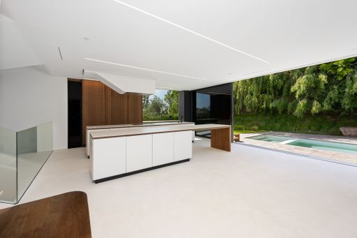 Spacious poolside area with island and glass walls