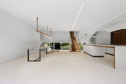 Spacious room with furniture and wooden table beneath stairs