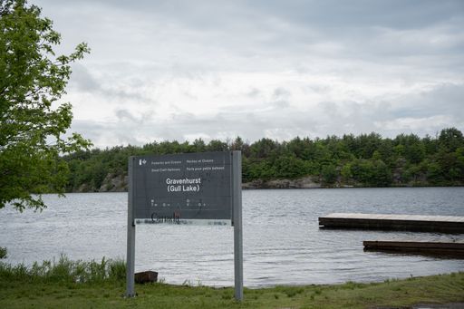Waterside view of the Canadian government welcome sign for an empty park at Gil lake in Gravenhurst Ontario