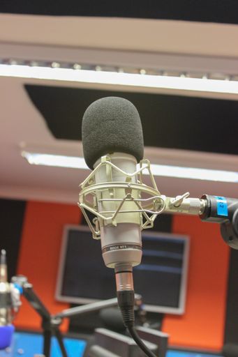 A vertical closeup of a microphone in the studio.