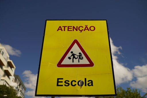 A closeup shot of a yellow warning sign on a blue sky background