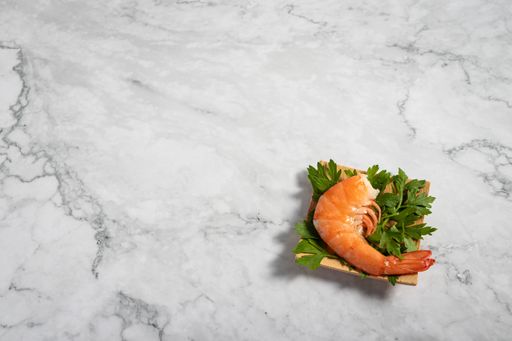 A delicious appetizer on a small wooden plate on a marble texture table