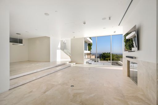 A spacious living room with a large flat-screen TV mounted on a white wall. California, USA
