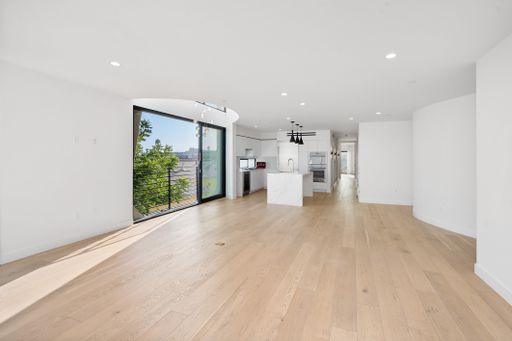 A spacious living room with hardwood floors and glass doors opening to the yard. California, USA