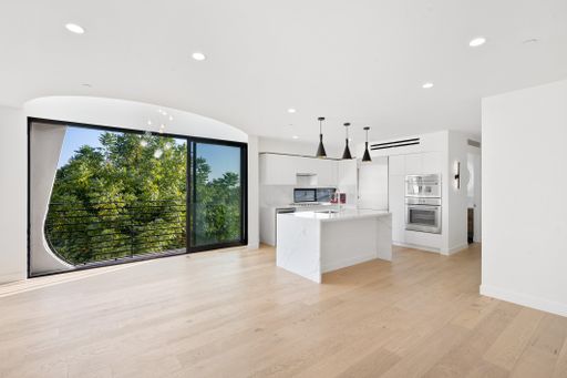 A spacious living room with a kitchen and wooden flooring. California, USA