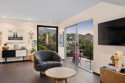 A spacious living room with hardwood floors and tall windows. Los Angeles, California