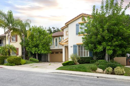 A two-story house with a garage and front yard trees. California, USA