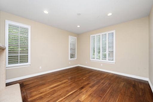 A spacious room with hardwood floors and windows with white blinds. California, USA