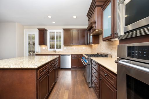 A spacious kitchen with hardwood floors and brown cabinets. California, USA