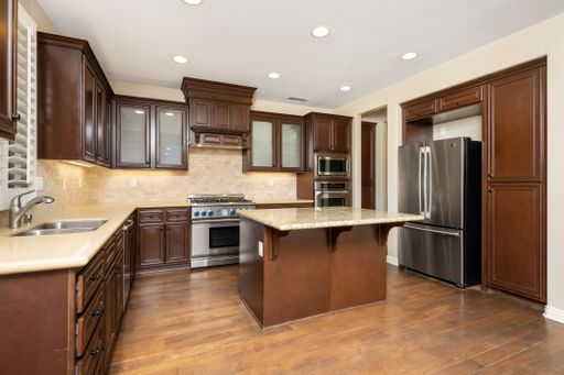 A spacious kitchen with hardwood floors and brown cabinets. California, USA