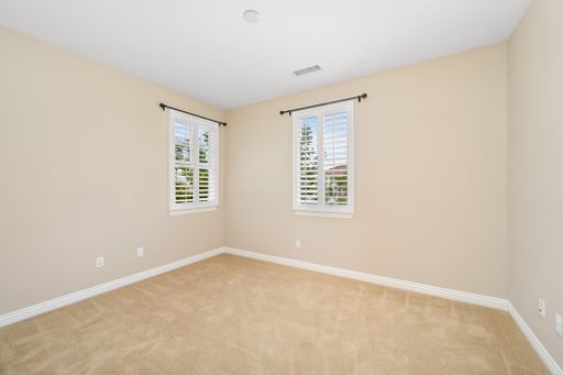 An empty room with two windows and tan walls. California, USA