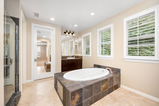 A spacious bathroom with tiled floors, windows, and a bathtub. California, USA
