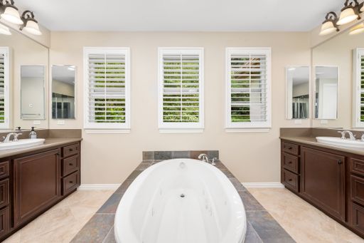 A spacious bathroom with tiled floors, windows, and a bathtub. California, USA