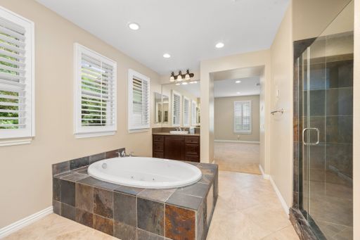 A spacious bathroom with tiled floors, windows, and a bathtub. California, USA