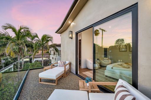 A patio adorned with white furniture, lush plants, and palm trees. California, USA