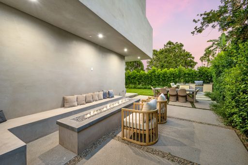 An outdoor table and chairs on a patio with green vegetation in the background. California, USA
