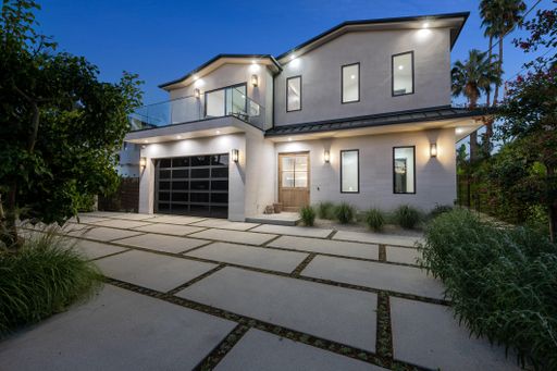 A house with a tiled driveway and lush greenery in the garden. California, USA