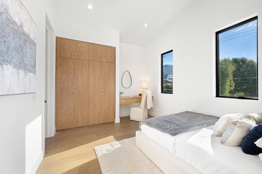 The soft pillows on the bed near a window in a modern bedroom