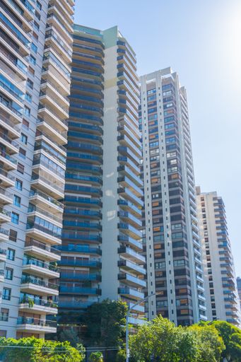 The tall buildings nestled among lush green trees in an urban setting. Buenos Aires, Argentina