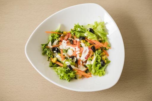 A high angle shot of a vegetable salad in a white bowl - perfect for a food blog