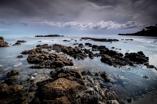 The rock formations in the sea under the cloudy sky