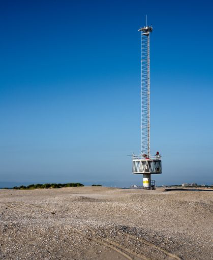 A vertical shot of the sand engine under a clear blue sky on a hot day in the desert