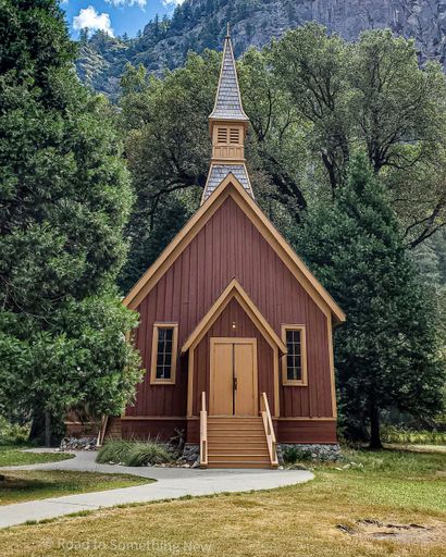 A charming wooden chapel surrounded by lush greenery and mountains in Yosemite National Park.