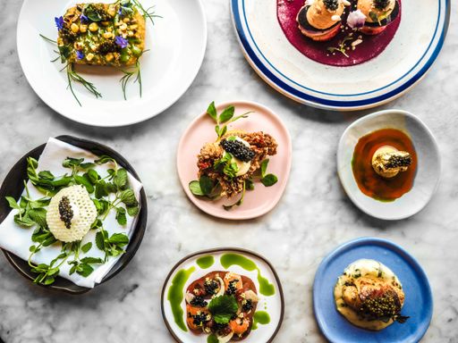 An overhead shot of side dishes with golden caviar on top in different plates