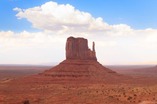 A scenic view of Monument Valley with a long road leading into the distance in Arizona, USA