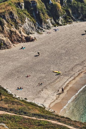 A vertical shot of people at the beach shore in Coruna Spain
