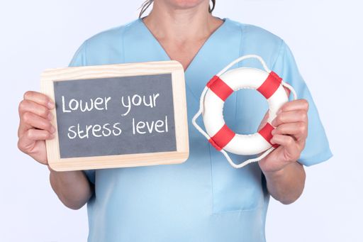 A blackboard with ''Lower your stress level'' written on it and a lifebuoy in the hands of a doctor