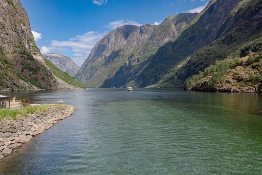 A scenic view of Naeroydalselvi river flowing in Gudvangen village on a sunny day in Aurland Municipality in Vestland county, Norway