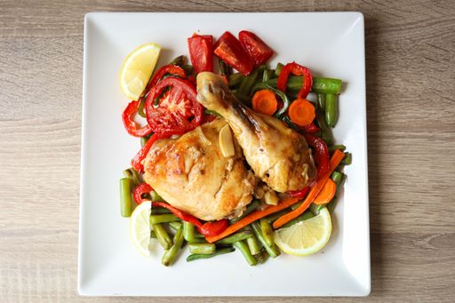 A delicious plate of roasted chicken thighs with mixed vegetables on a plate