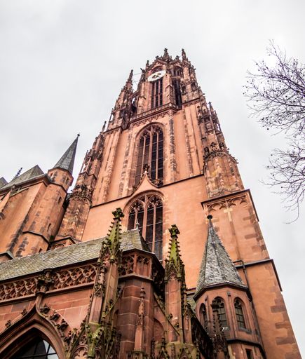 A low angle shot of an external view of St. Bartholomew cathedral against a cloudy sky in Frankfurt