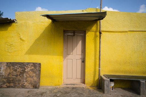 A scenic view of an old yellow wall and a door