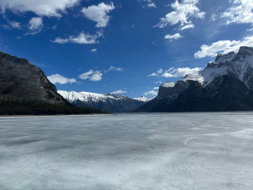 A stunning view of a frozen lake Minnewanka with snow-capped mountains in Banff National Park, Canada
