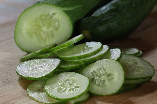 a close-up of sliced cucumber on a wooden cutting board