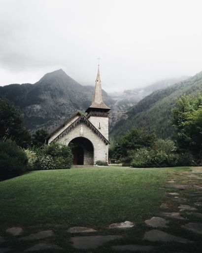 A charming church against a backdrop of misty mountains. Les Praz, Chamonix, France