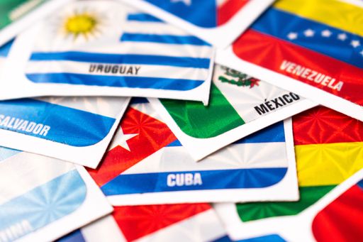A closeup shot of various international flag stickers scattered on a surface, with a blur background