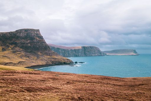 Scenic view of Neist Point cliffs and the ocean on the Isle of Skye, Scotland, under a cloudy sky