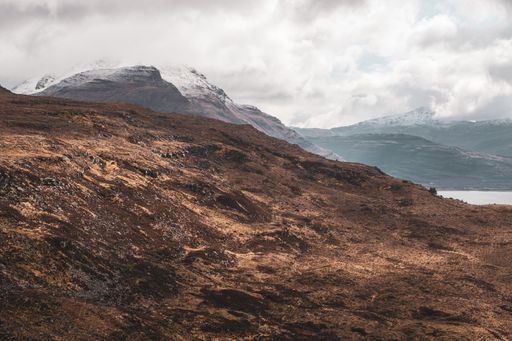 A scenic Scottish Highlands disappearing into misty mountains, with dense foliage on either side