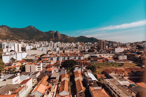 An aerial shot of cityscape with red roofs and a mountain in the background