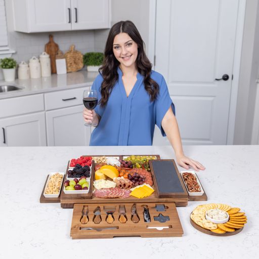 A woman enjoying a glass of red wine with a charcuterie board in a modern kitchen