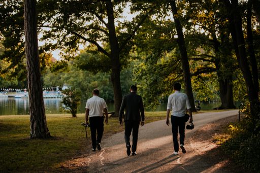 An actor and two cameramen walking through the narrow footpath in search of a place to shoot
